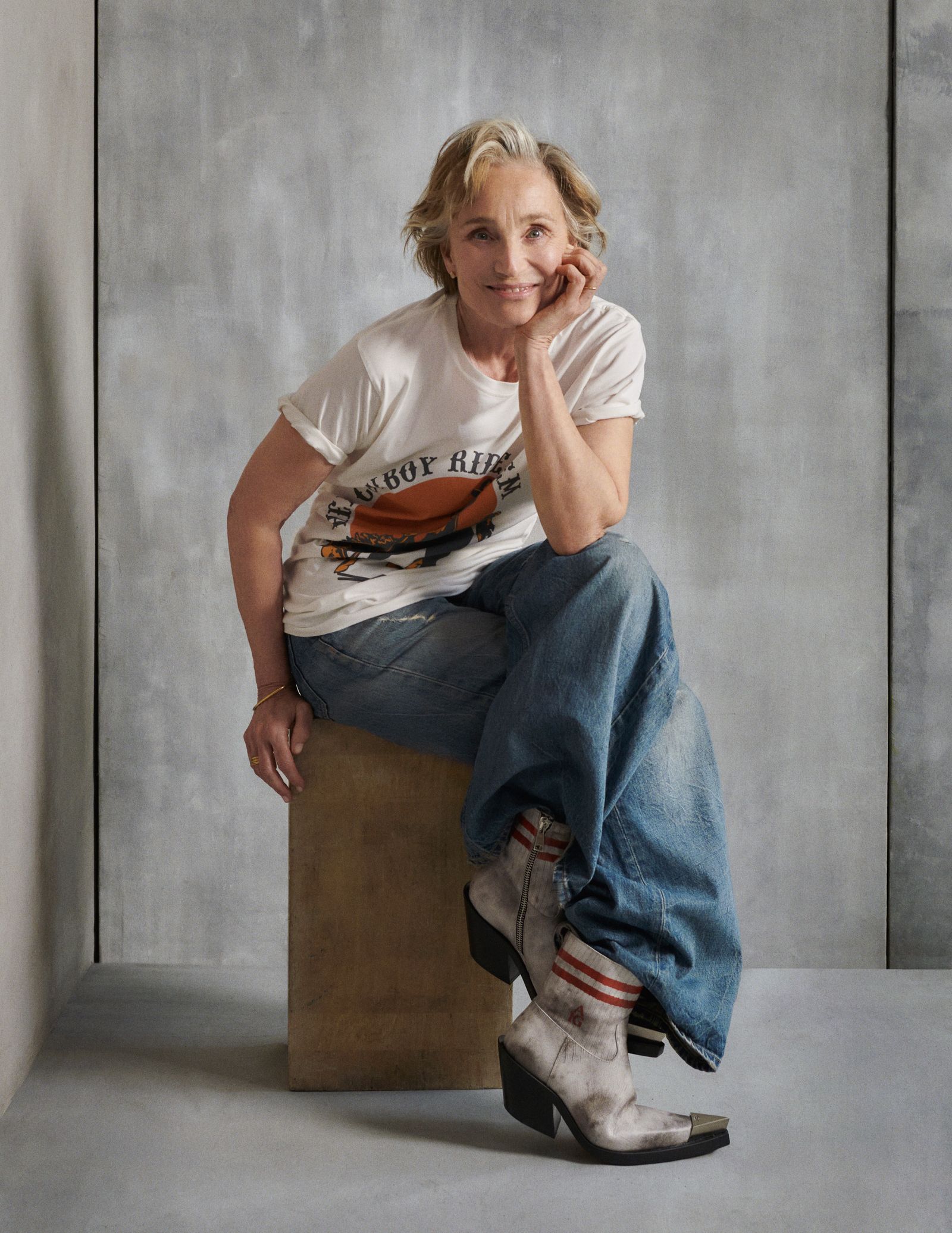 Images may contain Kristin Scott Thomas clothing shoes sitting in pants face and photography